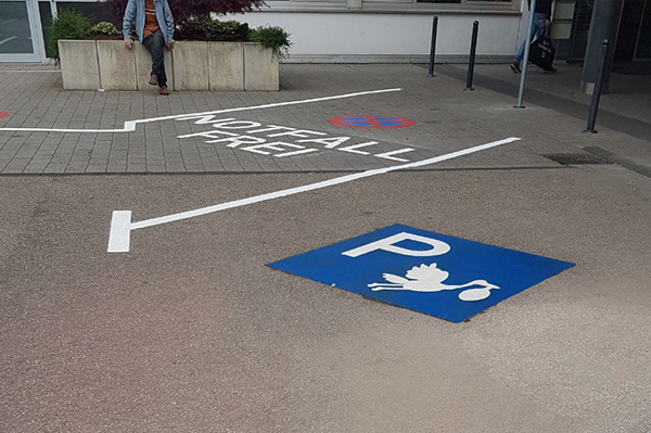 Parkeringsplads med blåt storkesymbol
